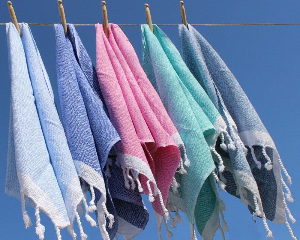 die verschiedenen Farben des Hamam Handtuch Capri hängen nebeneinander an der Wäscheleine